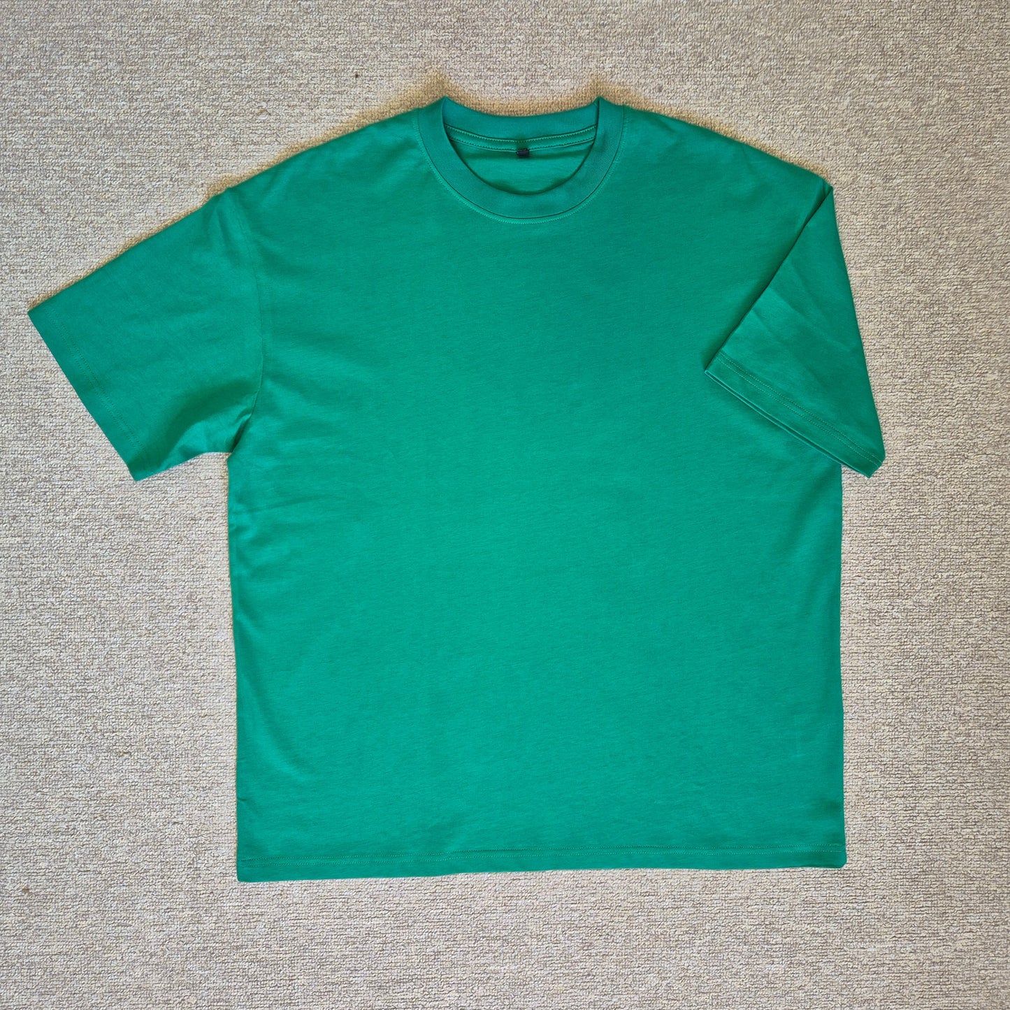 Green t-shirt on a gray textured surface