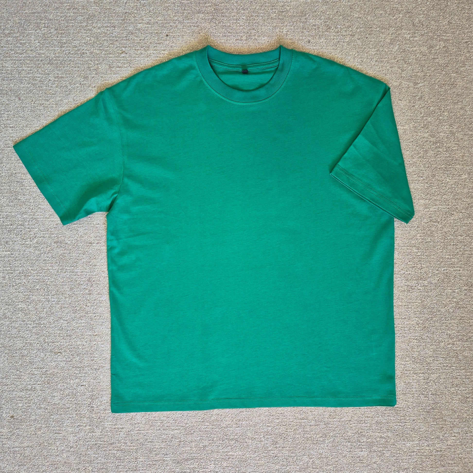 Green t-shirt on a gray textured surface