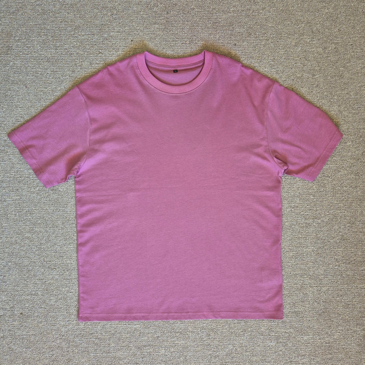 Pink t-shirt on a beige carpet